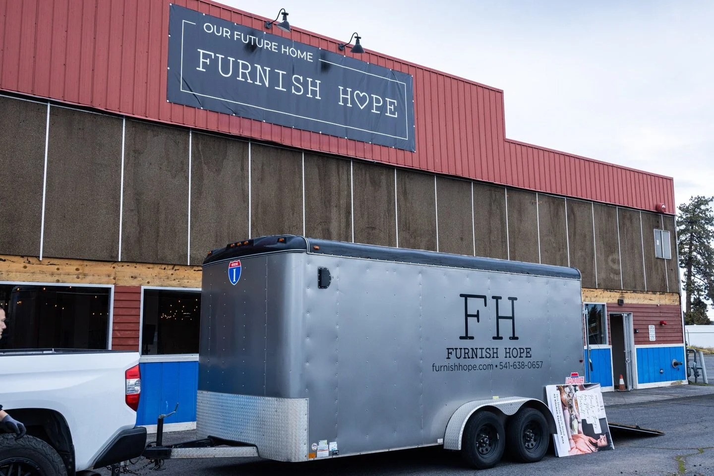 A trailer parked in front of a building with a sign that reads