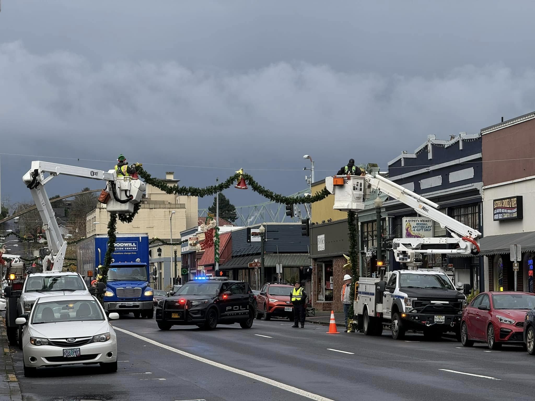 Street scene with trucks and cars decorating for a holiday, dark cloudy sky overhead.