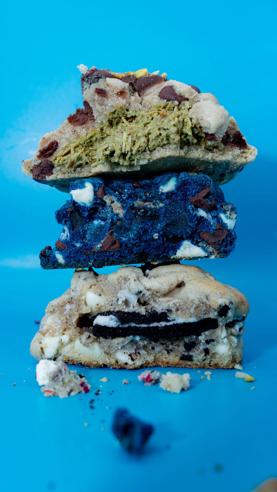 Stacked ice cream sandwiches with various flavors and colors on a blue background.