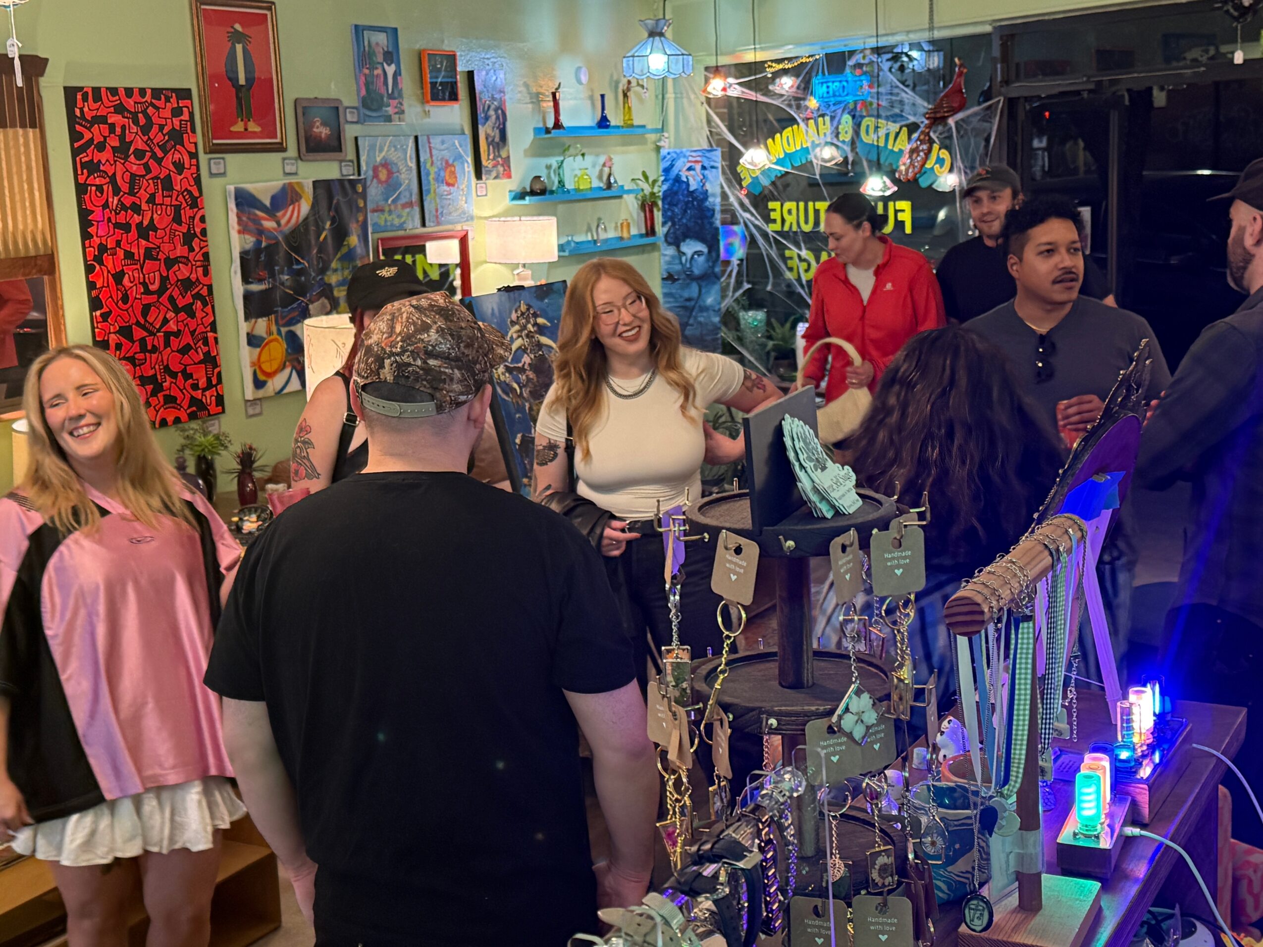 People gather around a crowded display counter in a brightly decorated shop.