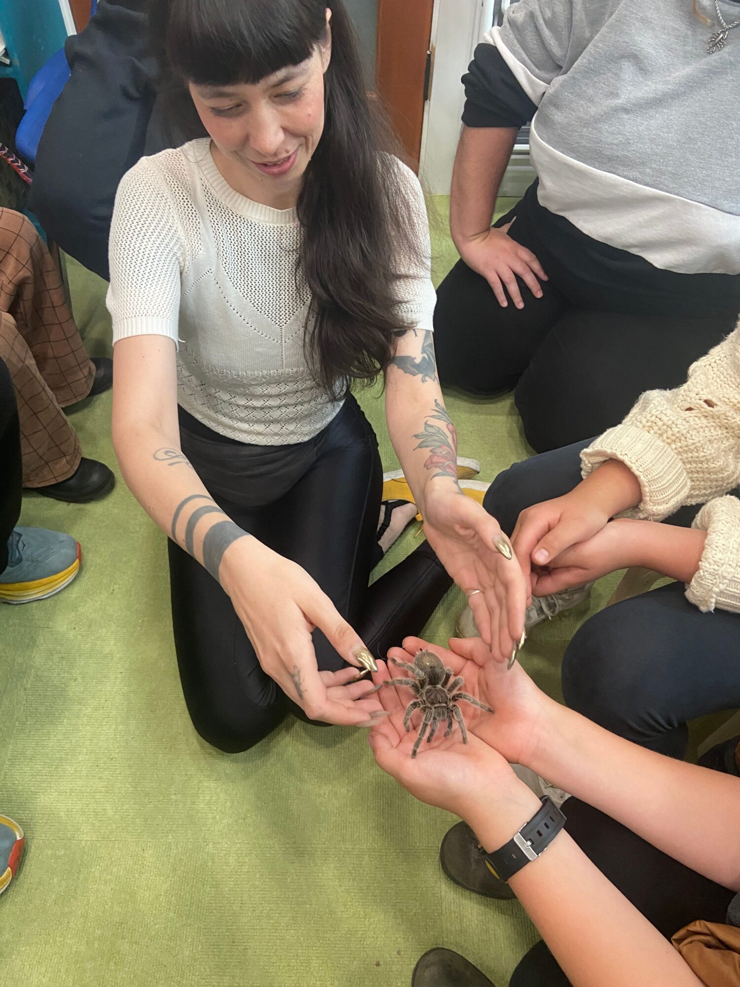 Several people gather around a small plant held in their hands.